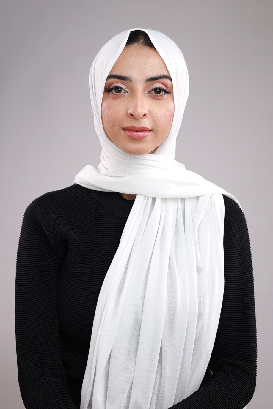Model wearing a White Cotton Jersey Hijab in soft, non-slippery fabric. Full-coverage hijab for sale in Pakistan.