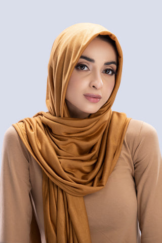 Model wearing a Almond Cotton Jersey Hijab in soft, non-slippery fabric. Full-coverage hijab for sale in Pakistan.